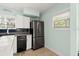 Modern kitchen with stainless steel fridge, sleek black dishwasher, and contrasting dark backsplash at 7 Clarendon Ct, Daytona Beach, FL 32118