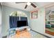 Relaxing porch with a TV, blue curtains, and colorful rug, perfect for outdoor entertainment at 7 Clarendon Ct, Daytona Beach, FL 32118