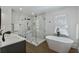 Primary bathroom featuring white marble tiles, freestanding tub, and glass shower at 718 E Livingston St, Orlando, FL 32803