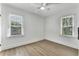 Empty, airy bedroom with hardwood floors and natural light from two windows at 718 E Livingston St, Orlando, FL 32803