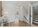 Bright hallway with hardwood floors, neutral walls, stairway, and an open doorway to a bedroom at 718 E Livingston St, Orlando, FL 32803