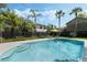 Inviting pool with steps, surrounded by palm trees and lush landscaping, creating a tropical oasis in the backyard at 718 E Livingston St, Orlando, FL 32803