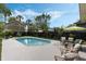 Backyard oasis with a sparkling pool, stylish seating, lush landscaping, and black privacy fence at 718 E Livingston St, Orlando, FL 32803