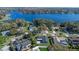 Scenic aerial view of a home with a dark gray roof, a lake, and surrounded by trees at 825 Rosemere Cir, Orlando, FL 32835