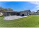 Wide view of backyard with paved patio, enclosed porch, and well maintained lawn at 825 Rosemere Cir, Orlando, FL 32835