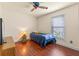 Cozy bedroom featuring hardwood floors, a comfortable bed, and a vintage-style fan and lamp at 825 Rosemere Cir, Orlando, FL 32835