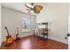 Bright bedroom with hardwood floors, ceiling fan, window, and desk and two guitars in the corner at 825 Rosemere Cir, Orlando, FL 32835
