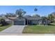 Charming single-story home with a well-manicured lawn, elegant gray brick driveway, and lush landscaping at 825 Rosemere Cir, Orlando, FL 32835