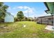 Spacious backyard with a shed, green grass, and a wood fence, perfect for outdoor activities at 864 Naples Dr, Orlando, FL 32804