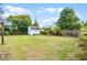Wide backyard with a well-maintained lawn, surrounded by a wooden fence and shady trees at 864 Naples Dr, Orlando, FL 32804