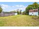Wide backyard with a well-maintained lawn, surrounded by a wooden fence and shady trees at 864 Naples Dr, Orlando, FL 32804