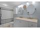 Bright bathroom featuring a double vanity, decorative mirrors, and a shower with a stylish curtain at 864 Naples Dr, Orlando, FL 32804