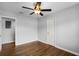 A bedroom with hardwood floors, ceiling fan, neutral walls, and two doorways at 864 Naples Dr, Orlando, FL 32804