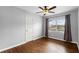 A bedroom with hardwood floors, ceiling fan, neutral gray walls, a window with curtains and a closet at 864 Naples Dr, Orlando, FL 32804
