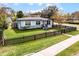The house has a well-manicured lawn and a charming black picket fence, and lovely curb appeal at 864 Naples Dr, Orlando, FL 32804