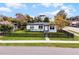 The house has a well-manicured lawn and a charming black picket fence, and lovely curb appeal at 864 Naples Dr, Orlando, FL 32804