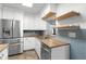Updated kitchen with stainless steel appliances, white cabinets, wood countertops, and sleek backsplash at 864 Naples Dr, Orlando, FL 32804