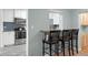 Modern kitchen with stainless steel appliances, breakfast bar, and a stylish blue tile backsplash at 864 Naples Dr, Orlando, FL 32804