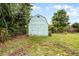 Backyard shed surrounded by trees, greenery, and a chain link fence at 864 Naples Dr, Orlando, FL 32804