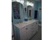 The bathroom features a double sink vanity, black and white flooring, and blue walls at 876 Lobster Ct, Kissimmee, FL 34744