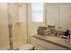 Bright bathroom showcasing a glass-enclosed shower, neutral tile, and a granite countertop at 8914 Caroline Bay Ct, Kissimmee, FL 34747