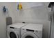 Bright laundry room features modern, front-loading washer and dryer and convenient shelving for storage at 8914 Caroline Bay Ct, Kissimmee, FL 34747