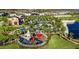 Aerial view of the community playground featuring a gated play area and colorful slides and lush landscaping at 8914 Caroline Bay Ct, Kissimmee, FL 34747