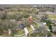 A birds eye view of a home in a well-manicured community featuring lush tree coverage and green lawns at 892 Cool Springs Cir, Ocoee, FL 34761