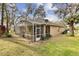 Cozy backyard featuring a screened lanai, lush landscaping, and a well-maintained lawn for outdoor enjoyment at 892 Cool Springs Cir, Ocoee, FL 34761