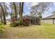 The backyard presents a spacious screened lanai, mature trees, and well-manicured lawn for outdoor relaxation and recreation at 892 Cool Springs Cir, Ocoee, FL 34761