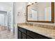 Bathroom vanity with granite countertop, dark cabinets and decorative, woven-design mirror frame at 892 Cool Springs Cir, Ocoee, FL 34761