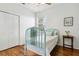 Bright bedroom featuring hardwood floors, a ceiling fan, a side table, and double door closet at 892 Cool Springs Cir, Ocoee, FL 34761