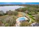 Aerial view of a community pool, featuring lounge chairs, playground, sport court and trees for outdoor recreation at 892 Cool Springs Cir, Ocoee, FL 34761