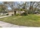 Tan single-story home with mature trees, green lawn, and attached garage at 892 Cool Springs Cir, Ocoee, FL 34761