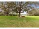 A serene park view with a bench under a large tree, overlooking a calm body of water at 892 Cool Springs Cir, Ocoee, FL 34761