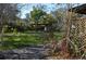 Serene backyard with a wooden pergola, mature trees, and path, creating a peaceful outdoor retreat at 933 Lakehurst St, Lakeland, FL 33805