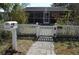 Cottage-style home with a screened-in porch, charming white picket fence, and well-maintained landscaping at 933 Lakehurst St, Lakeland, FL 33805