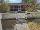 Inviting home featuring a cozy front yard with a white picket fence and walkway, enhancing curb appeal at 933 Lakehurst St, Lakeland, FL 33805