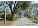 Street view showcasing mature trees and glimpse of the lake nearby at 933 Lakehurst St, Lakeland, FL 33805