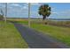 Community walking path borders lake with palm tree and utility poles at 933 Lakehurst St, Lakeland, FL 33805