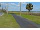 Community walking path borders lake with palm tree and utility poles at 933 Lakehurst St, Lakeland, FL 33805
