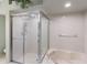 Bright bathroom featuring a glass-enclosed shower and soaking tub at 1075 Kensington Park Dr # 203, Altamonte Springs, FL 32714