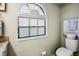 Well-lit bathroom featuring a toilet and a window with modern blinds at 1075 Kensington Park Dr # 203, Altamonte Springs, FL 32714