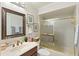 Bathroom featuring framed mirror, and shower with gold-framed doors at 1075 Kensington Park Dr # 203, Altamonte Springs, FL 32714