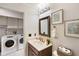 Bathroom with vanity, framed mirror, and laundry area at 1075 Kensington Park Dr # 203, Altamonte Springs, FL 32714