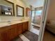 Bathroom with double sinks, wood cabinets and walk-in shower with glass door at 10753 Wilderness Ct, Orlando, FL 32821