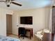 Bedroom with mounted TV, desk, chair, and neutral color scheme at 10753 Wilderness Ct, Orlando, FL 32821