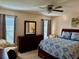 Comfortable bedroom with a ceiling fan, blue bedding, a dresser, and natural light at 10753 Wilderness Ct, Orlando, FL 32821