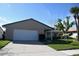 Charming front exterior showcasing a well-manicured lawn and attached garage at 10753 Wilderness Ct, Orlando, FL 32821