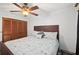 Cozy bedroom features a dark wood bedframe, a ceiling fan, and a large closet at 1113 Lyric Dr, Deltona, FL 32738